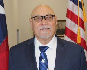 Profile Image for Commissioner Precinct 4-4A Bob Dupnik, standing between American and Texas Flags